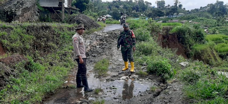 Bhabinkamtibmas Bersama Masyarakat Bersihkan Lokasi Bencana Tanah Longsor di Desa Bea Mese.